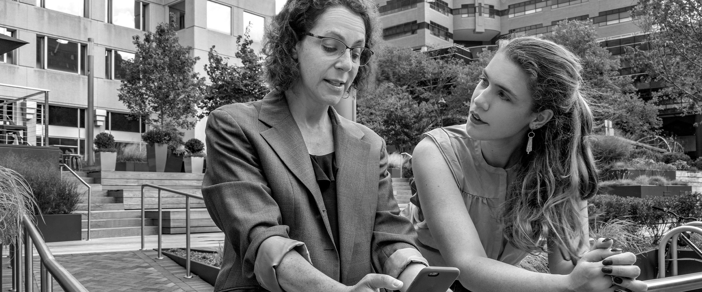 Michelle Ertischek and Erin Nealer talking outside in an urban environment.