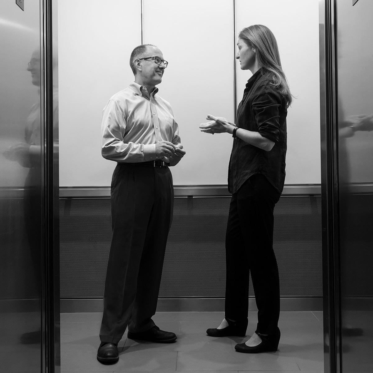 Pinney Associates Senior Leaders Joe Gitchell and Lucy Owen speaking in an elevator.
